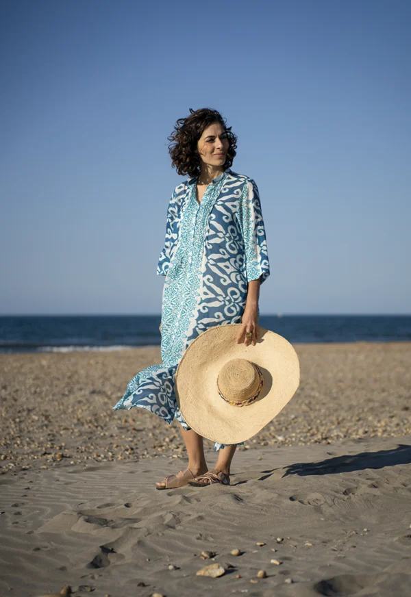 Photo posées une femme sur le sable en robe colorées