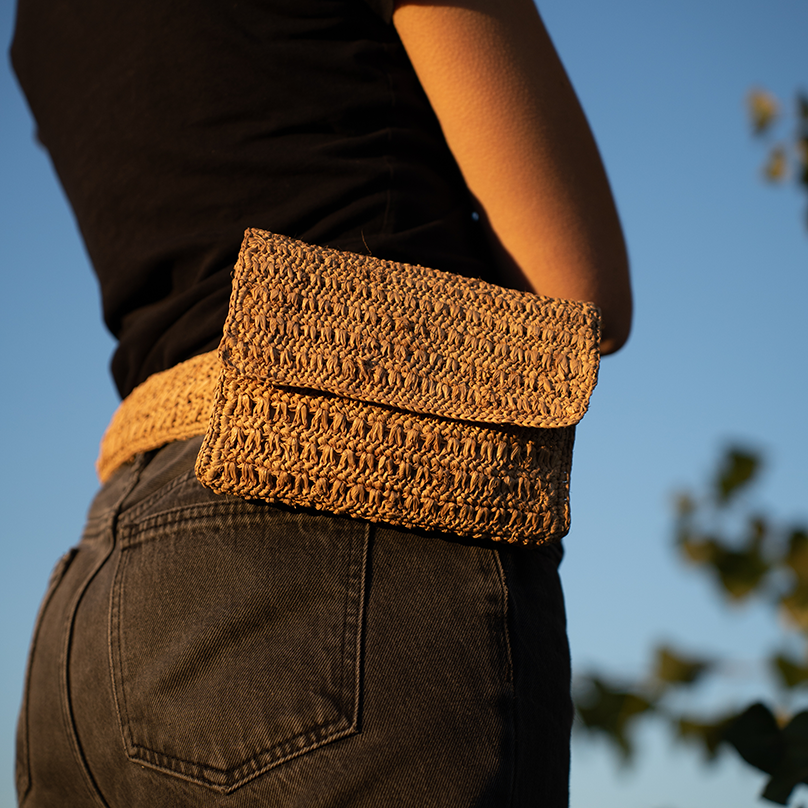 une femme avec une pochette beige portée à la ceinture Bagatelle France